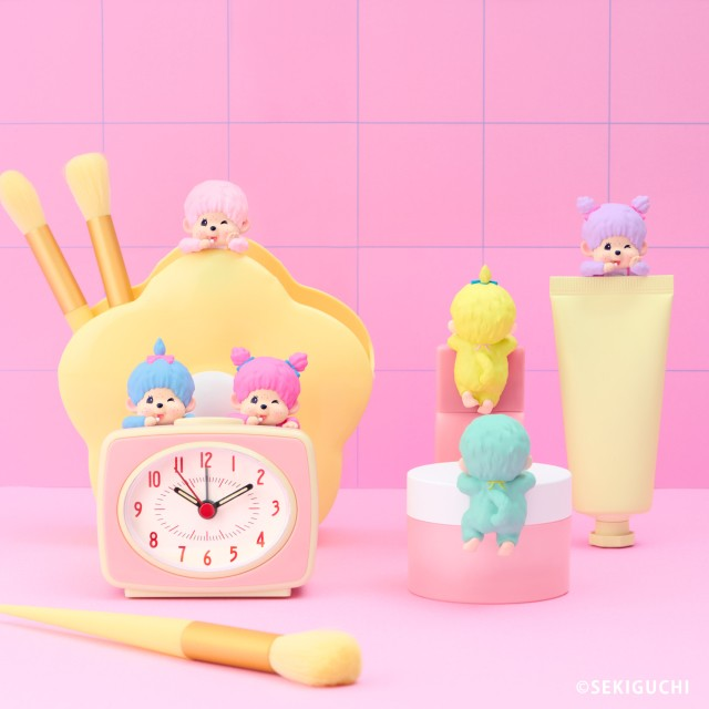 Monchhichi Hippers figures perched on a clock, cup and desk accessories