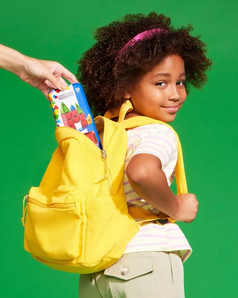 Girl putting the microMAGS tin in her backpack