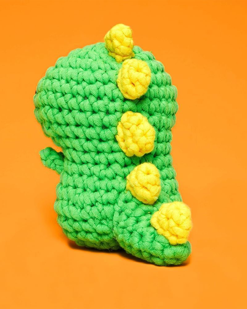 Back of the crocheted dinosaur showing its yellow spikes